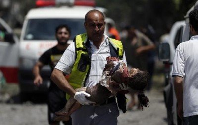 Un médecin palestinien évacue le corps d'une petite fille<small class="fine"> </small>? Chajaya, en banlieue est de Gaza, pilonnée le 20 juillet 2014 [<span class="caps">DR</span> Thomas Coex]