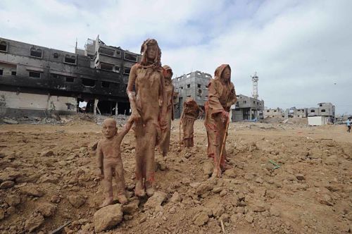 Exposition «<small class="fine"> </small>Tahaluk<small class="fine"> </small>» [Exténué] de l'artiste palestinien Iyad Sabbah, sur la plage de Gaza, une série de personnages en argile qui fuient leurs maisons, pour représenter le récent massacre perpétré par l'armée sioniste d'occupation dans le quartier de Shejaiya (source Jamal Dajani) - D.R
